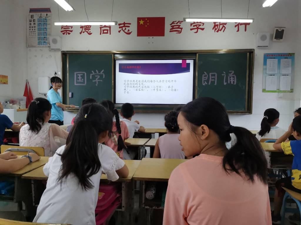 图为志愿者为学生讲解为什么要学习国学经典