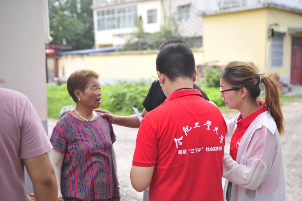 图1为数学之旅志愿者们正在像学生家长介绍暑期支教情况