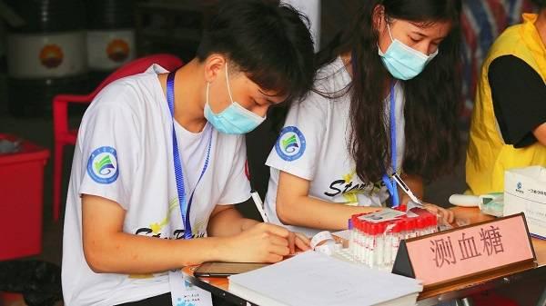 图为队员为登记个人信息，记录血糖测量值。广东医科大学 黄琬婷 提供