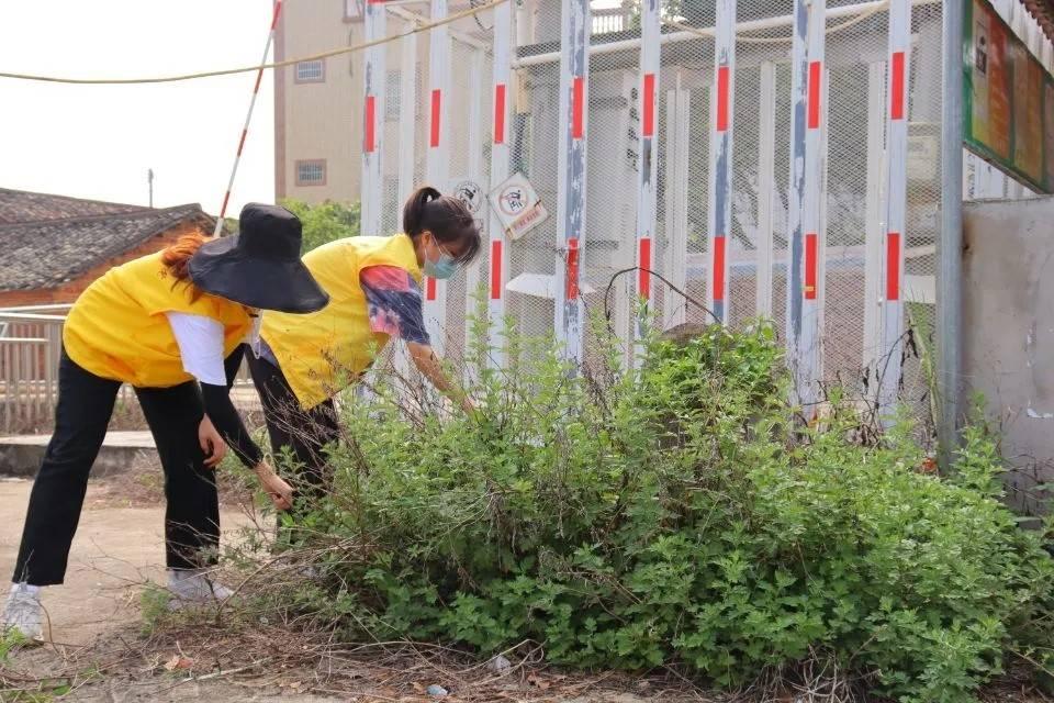 图为队员为村民清扫街道垃圾