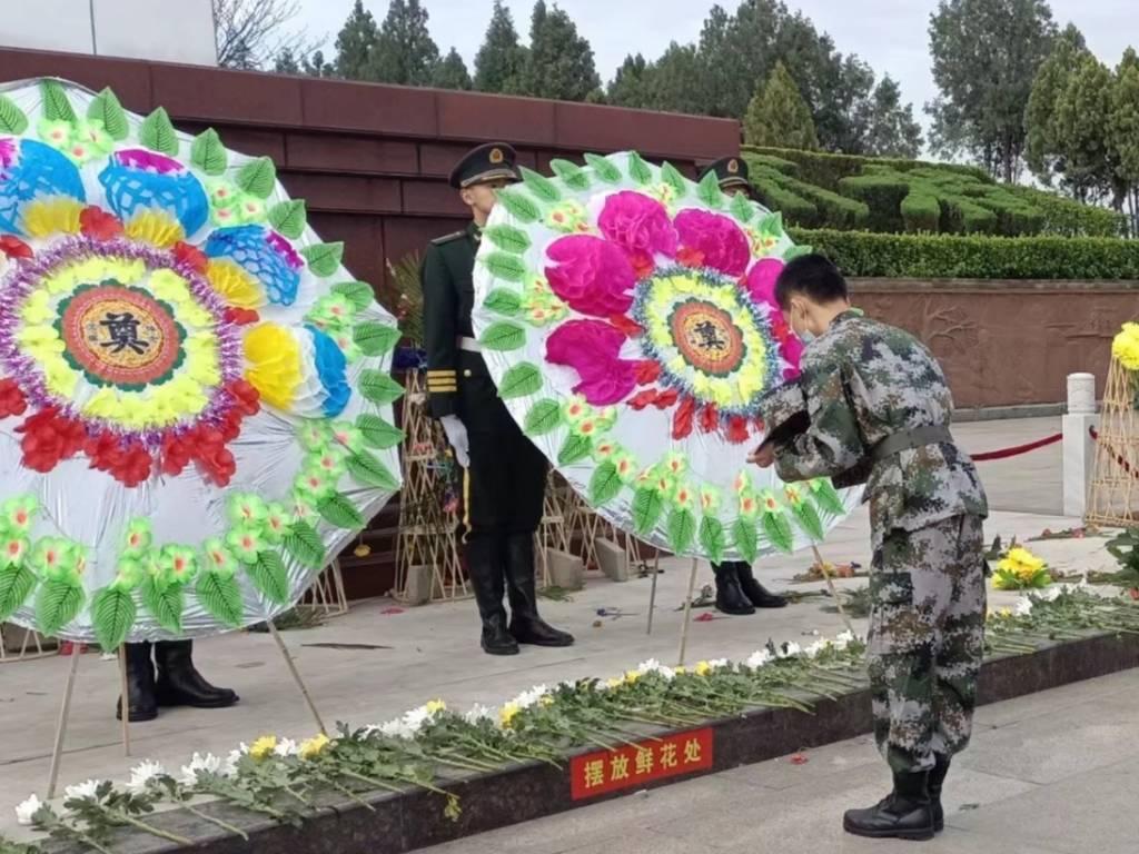 图片为志愿者为烈士送上祝福。