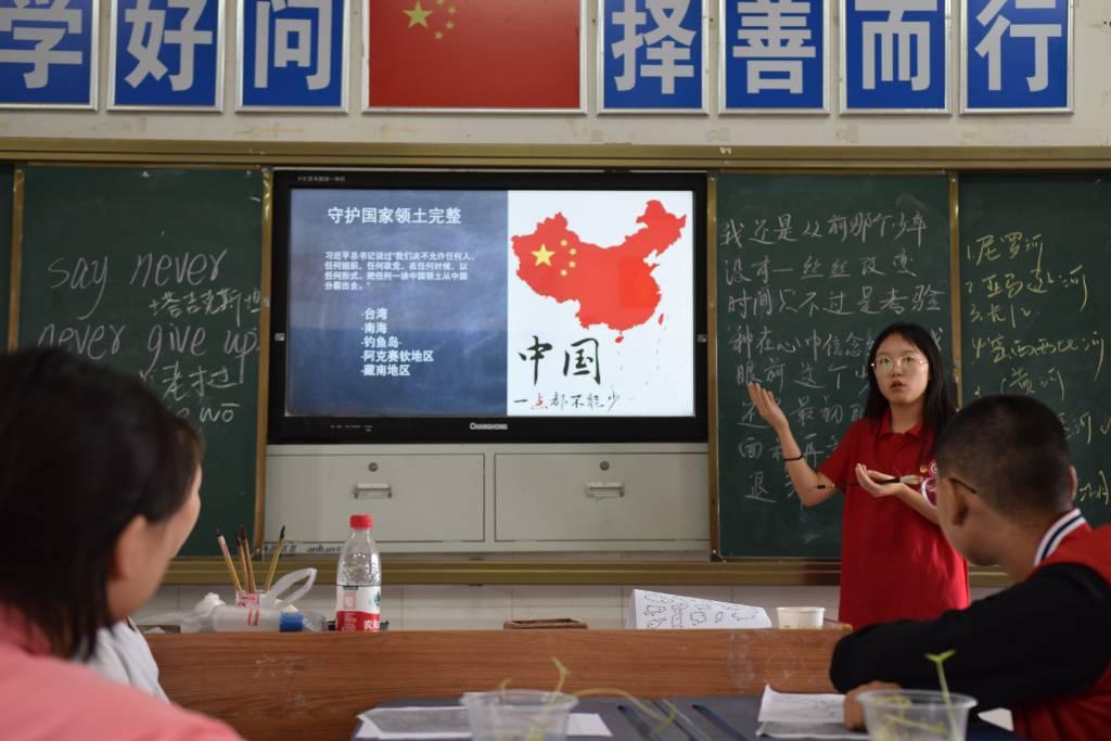 图为志愿者徐佳依在上地理课时，跟学生们强调捍卫国家主权与领土完整的重要性。通讯员 黄锦兰 摄