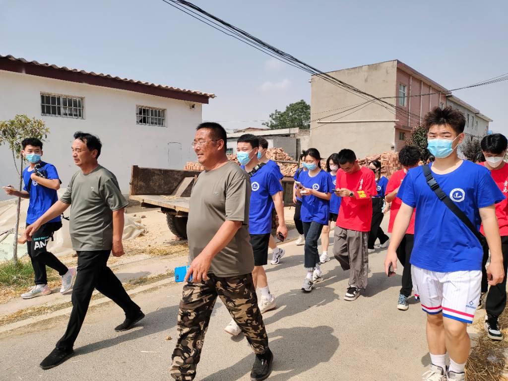 图为村长和书记带领实践团成员们走访慕庄村。