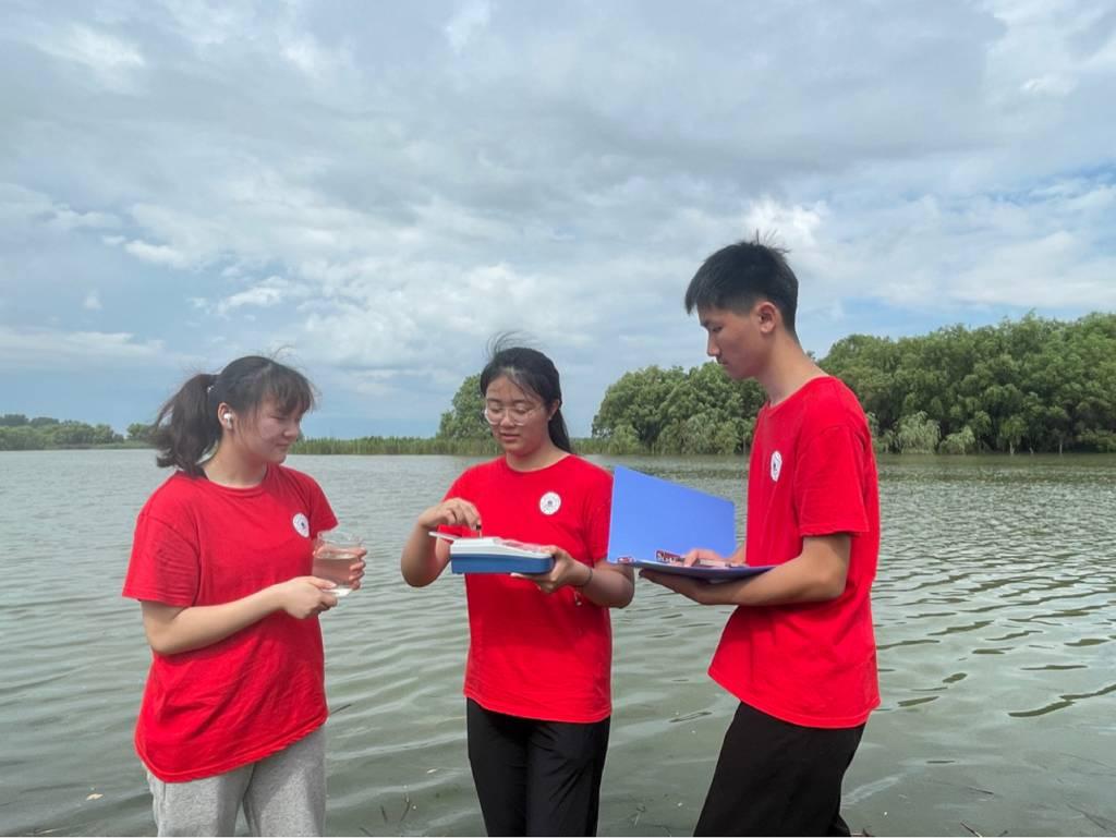 图为实践队员们在薛家洼生态园实地取水，检测水体浊度并记录。（通讯员 何玉洁 摄）