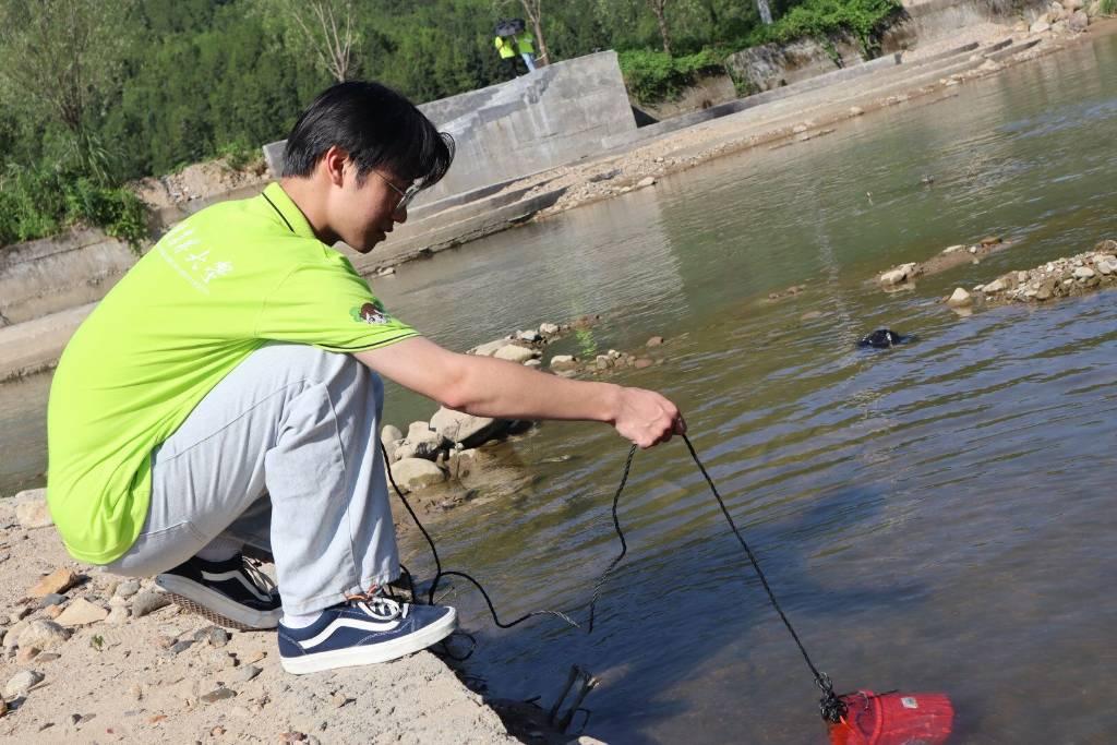 图为实践队员利用取水器采集水样