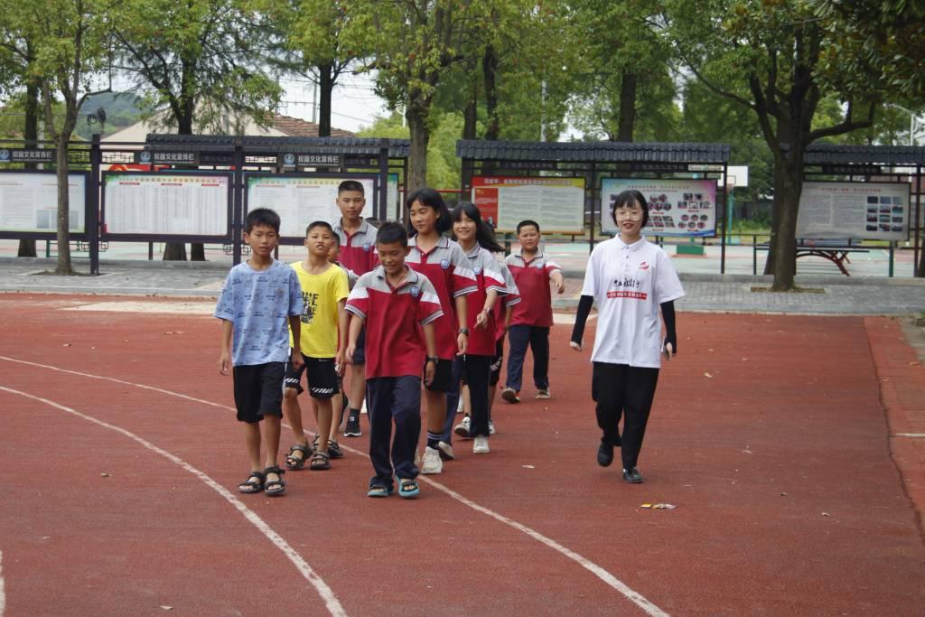 图为红船行支教老师李佳璇带领同学们到操场集合进行破冰游戏。