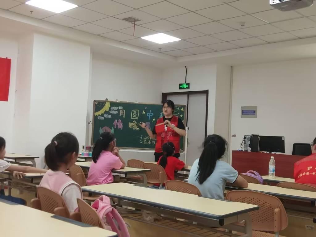 图为志愿者老师向学生介绍中国传统节日，学生们都聚精会神地聆听（大学生网报通讯员 刘菊芳摄）