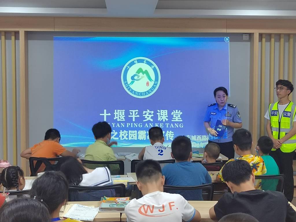 图为队员与民警对中小学生进行防溺水宣传教育 。中国青年网通讯员 胡希洋 供图﻿ ﻿﻿