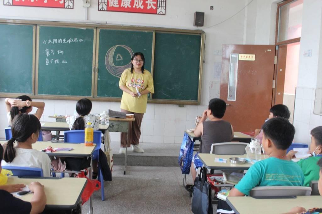 图为志愿者为四年级孩子们讲解太阳的结构，学生在课上积极表达自己对于宇宙的认识。