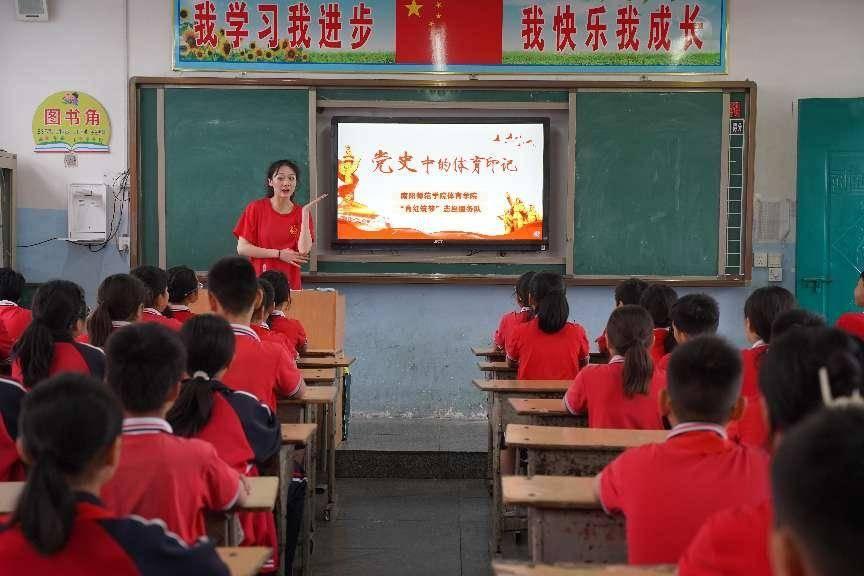 图为南阳师范学院体育学院实践队员为红军小学学生宣讲红色体育史