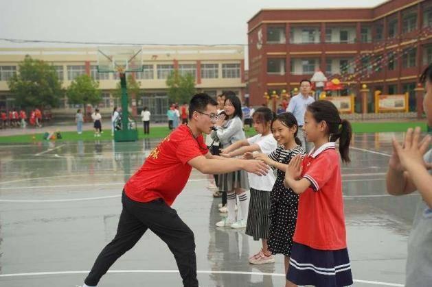 图为南阳师范学院体育学院实践队员为红军小学学生进行篮球专项教学