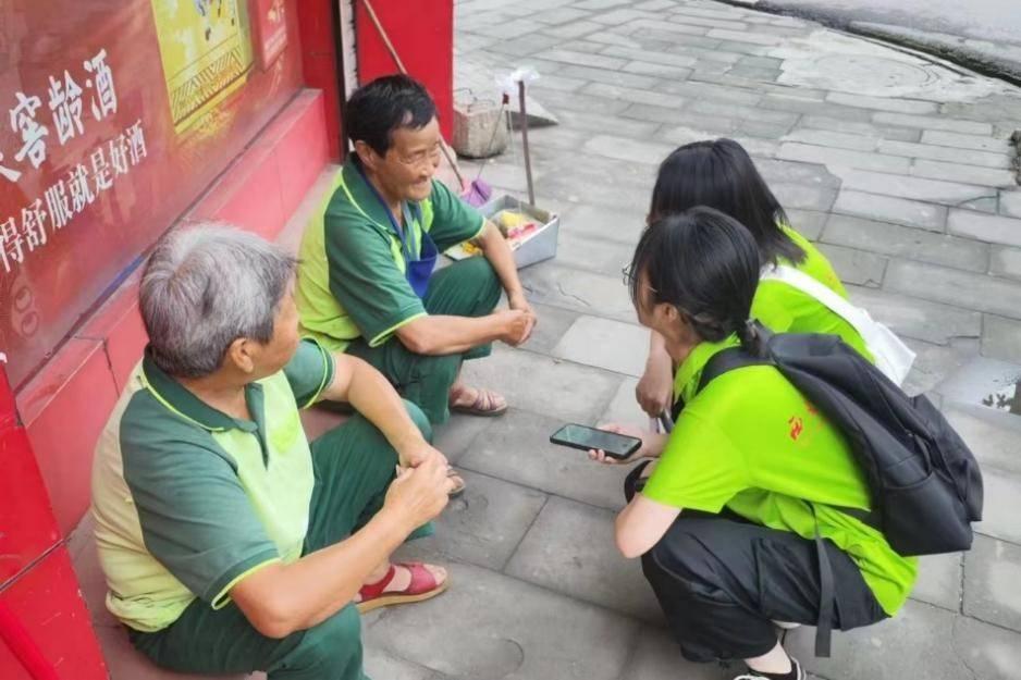 图为实践队队员访问环卫工人，了解其生活现状和对附近养老中心的了解和看法。通讯员 梁铭聪 摄