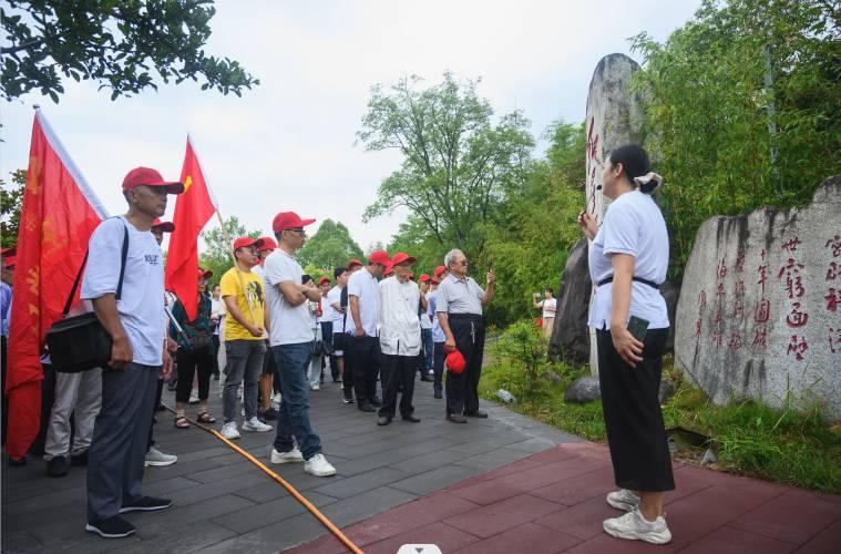 图为讲解员在红星公园特色建筑下为党员们讲解红军历史，一起缅怀红色历史，传承红色精神。