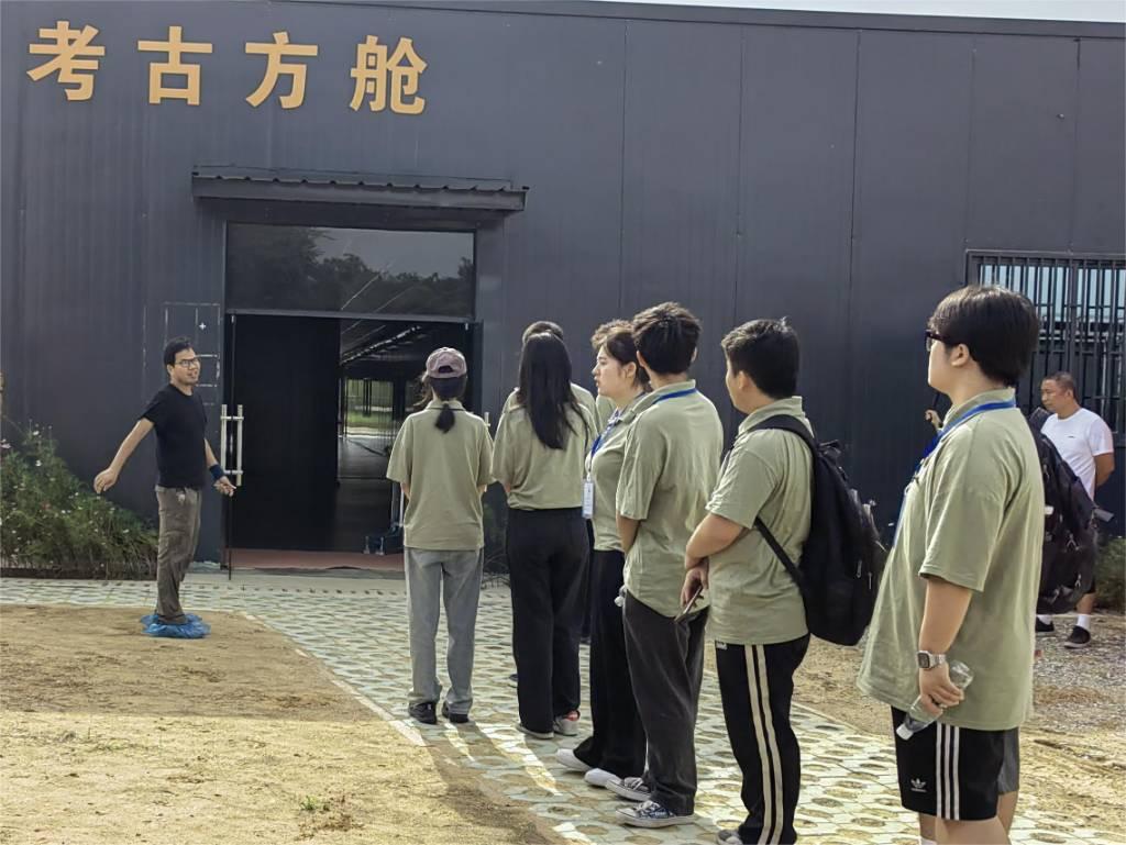 湖北汽车工业学院小火柴星火燎援志愿服务队一行11人驱车前往郧阳区青曲镇弥陀寺村学堂梁子遗址地进行对古人类新石器时代演化进行调研。图为志愿者前往方舱内考察。