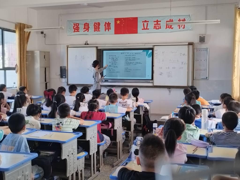 图为志愿者们为同学们上素描课。