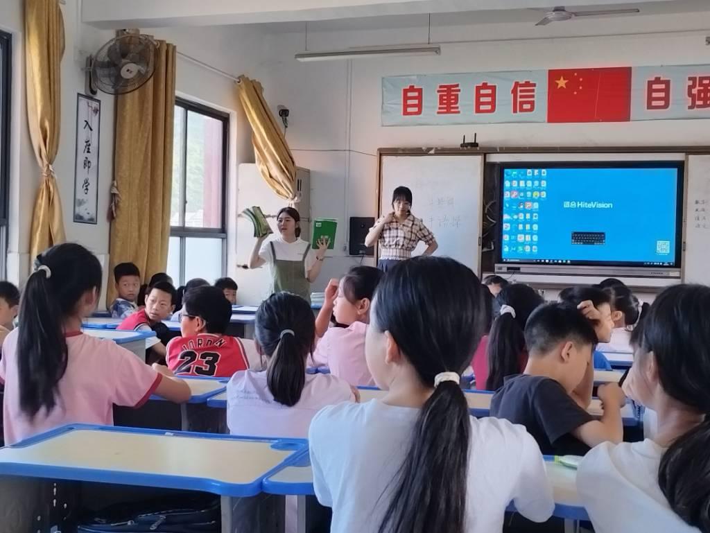 图为志愿者们为同学们发放学习资料。