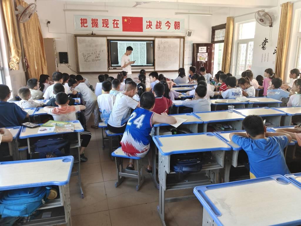 图为志愿者为同学们上书法课。