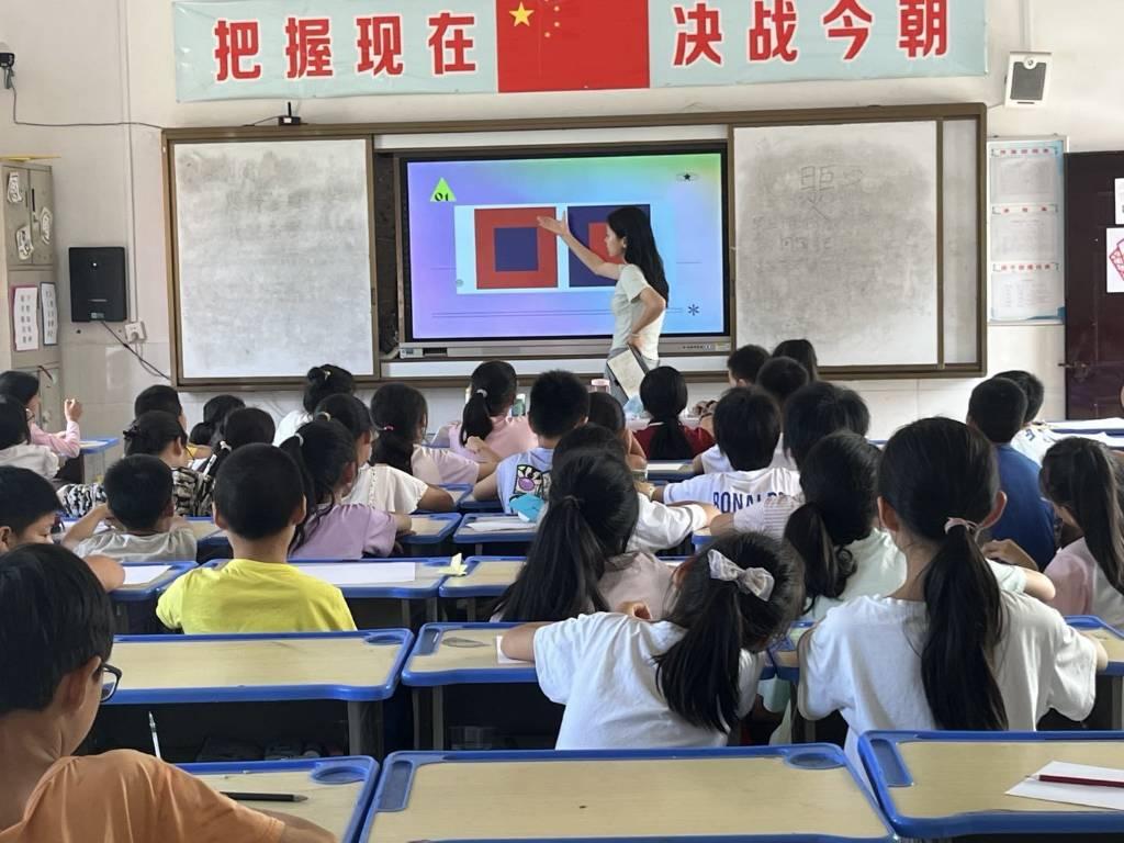 图为志愿者为同学们讲解素描必备条件。