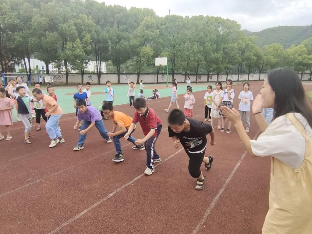 图为同学们在体育课上进行跑步比赛。跑步是一种有氧运动，可以增强心肺功能，改善血液循环，增强肌肉力量和耐力。通过跑步比赛，孩子们能够锻炼身体，提高身体素质，增强体力。跑步比赛可以是个人竞技，也可以是团队竞技。如果是团队比赛，孩子们需要相互合作，共同争取团队的胜利。这培养了他们的团队合作精神和集体荣誉感。体育课上的跑步比赛对孩子们的意义很多，不仅可以提高身体健康，还可以培养团队合作精神、竞争意识、奋斗精神，增强自信心，培养纪律和毅力等。这些都是孩子们成长中非常重要的品质和能力。