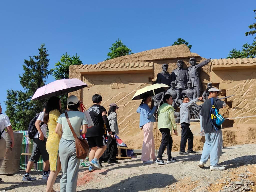 图为湖北汽车工业学院“星火燎援”暑期实践团队在调研地——玉皇山，即将登顶时目睹还原曾经战役的石人像（李肃阳 摄）