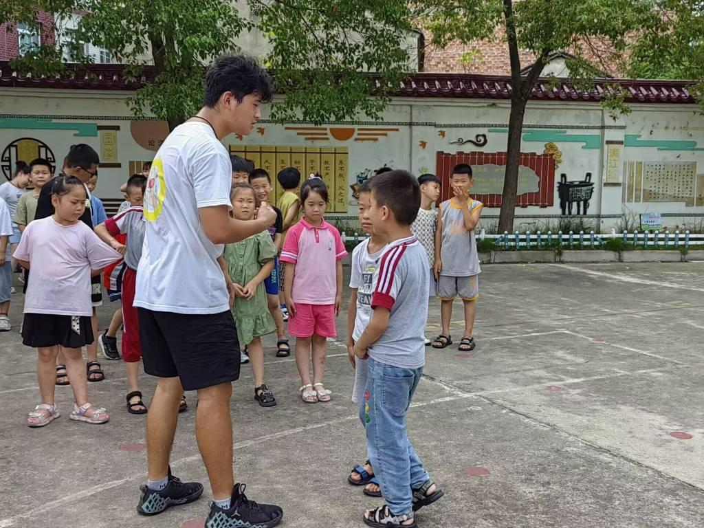 图为排球课上实践队员单独指导学生，帮助学生纠正不标准动作，便于后期进一步的学习。