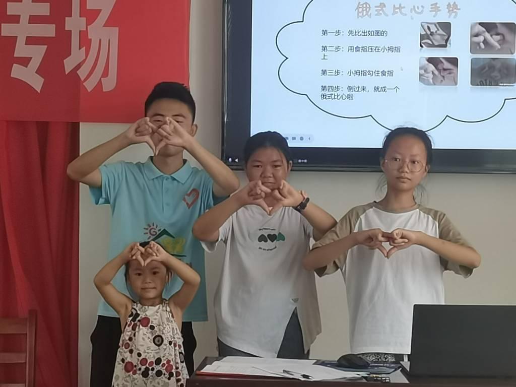 图为在手势舞蹈课上志愿者教会小朋友们一起学会比俄式比心。大学生网报通讯员 洪卓群 供图