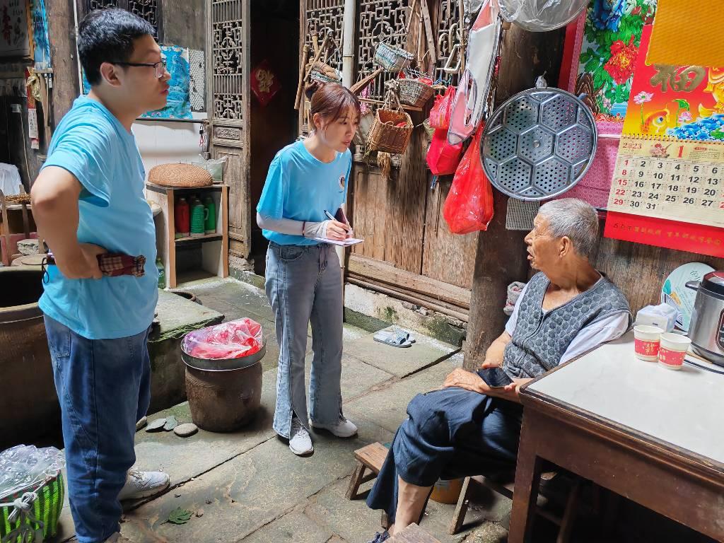 团队成员在黄山市歙县昌溪乡采访当地住户，询问当地古民居的保护和利用情况。