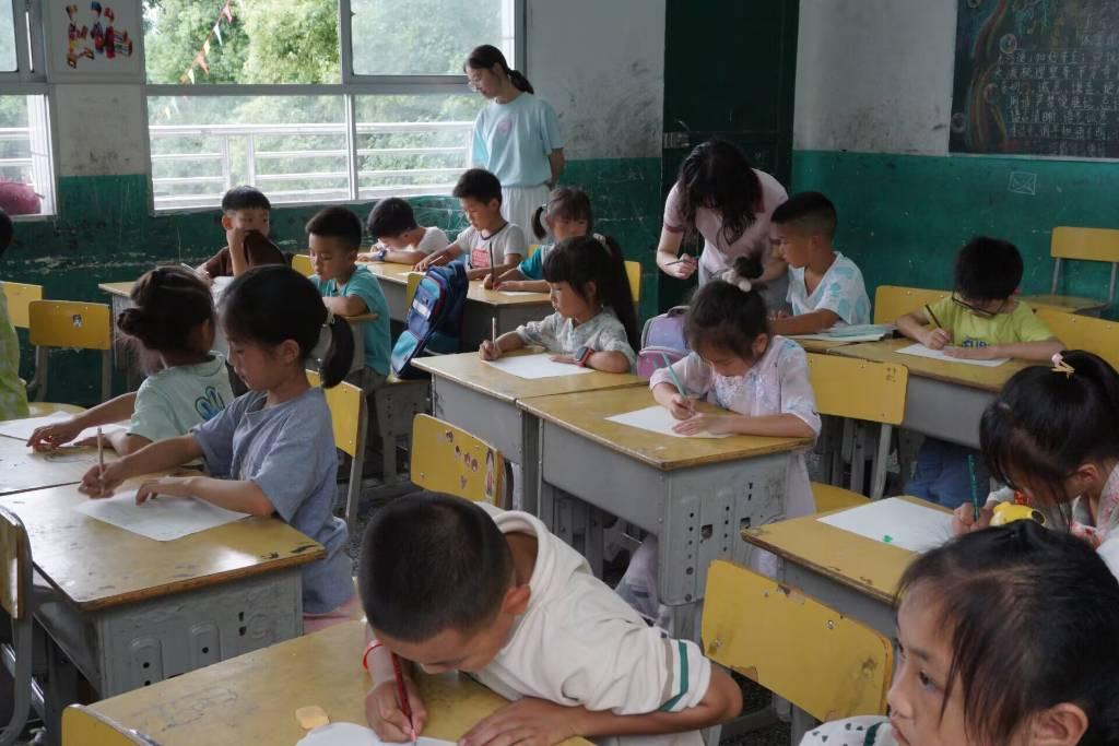 图为学生在完成自己的暑假作业时，支教队员在课上耐心地为学生进行课业辅导，讲解一些难题并且传授方法。通讯员田柯锐