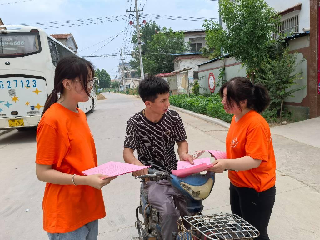 图为志愿者为家中有孩子的父亲解释讲普通话的好处。中国青年网通讯员 李静怡 供图