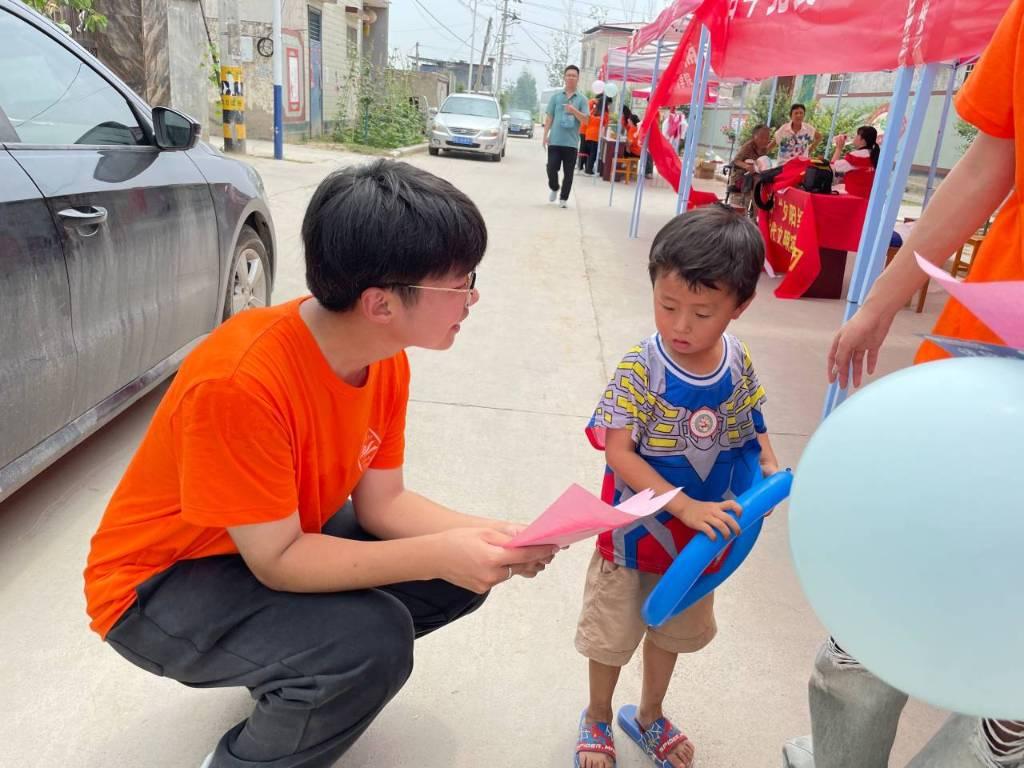 ﻿图为志愿者寻问小朋友心中的家乡是什么样子的。大学生网报网通讯员 李静怡 供图﻿