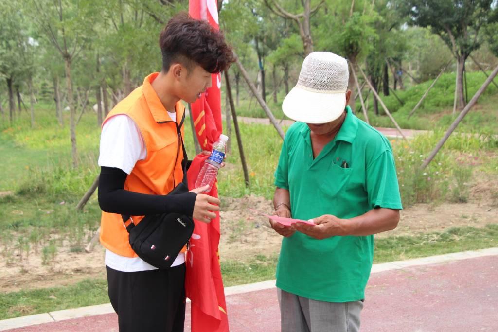 图为实践队员向漯河地区的路人发放新时代理论内容的宣传单。中国青年网通讯员 李静怡 供图