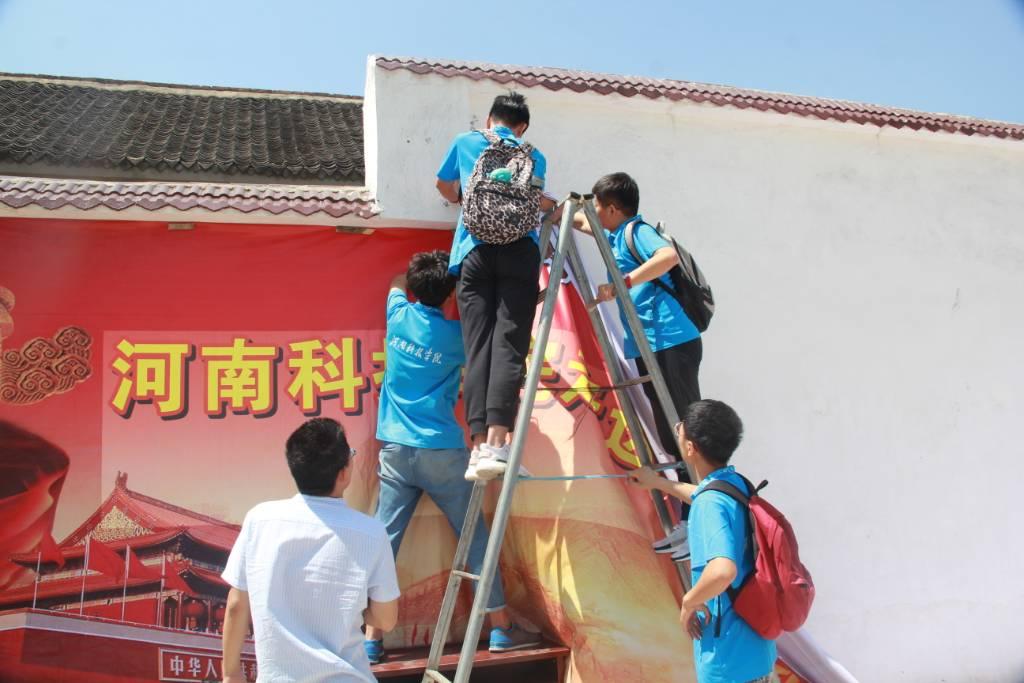 ﻿图为实践队员在漯河市乡镇地区的村里张贴新时代理论海报。中国青年网通讯员 李静怡 供图