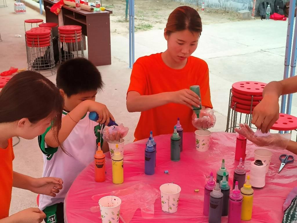 图为志愿者们在与孩子们一起做手工，丰富了孩子们的暑期生活。中国青年网通讯员 李静怡 供图