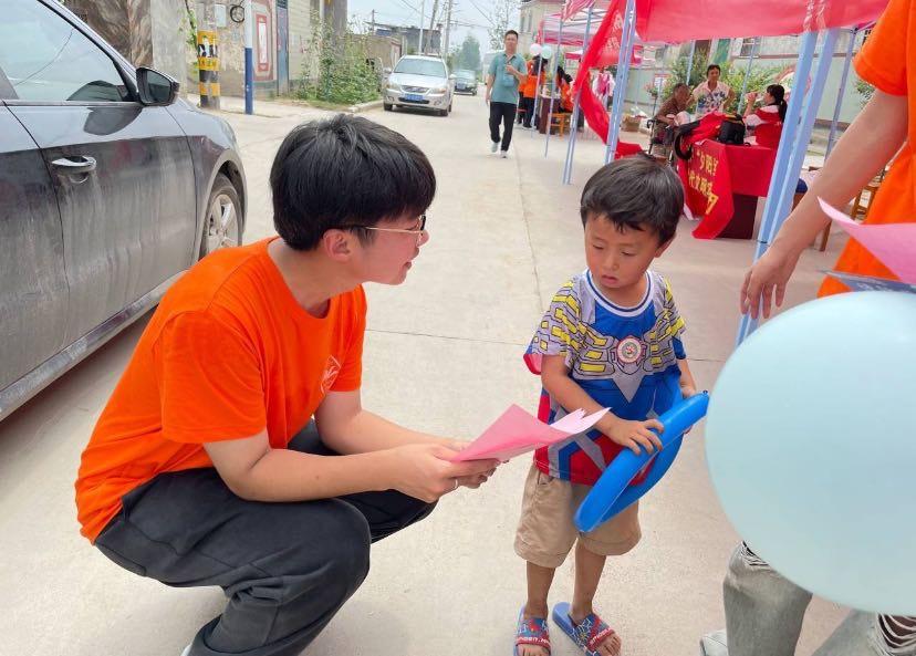 图为河南科技学院外国语学院学子细心向当地可爱的小朋友宣传新理论新思想 中国青年网 通讯员 汪洋 供图