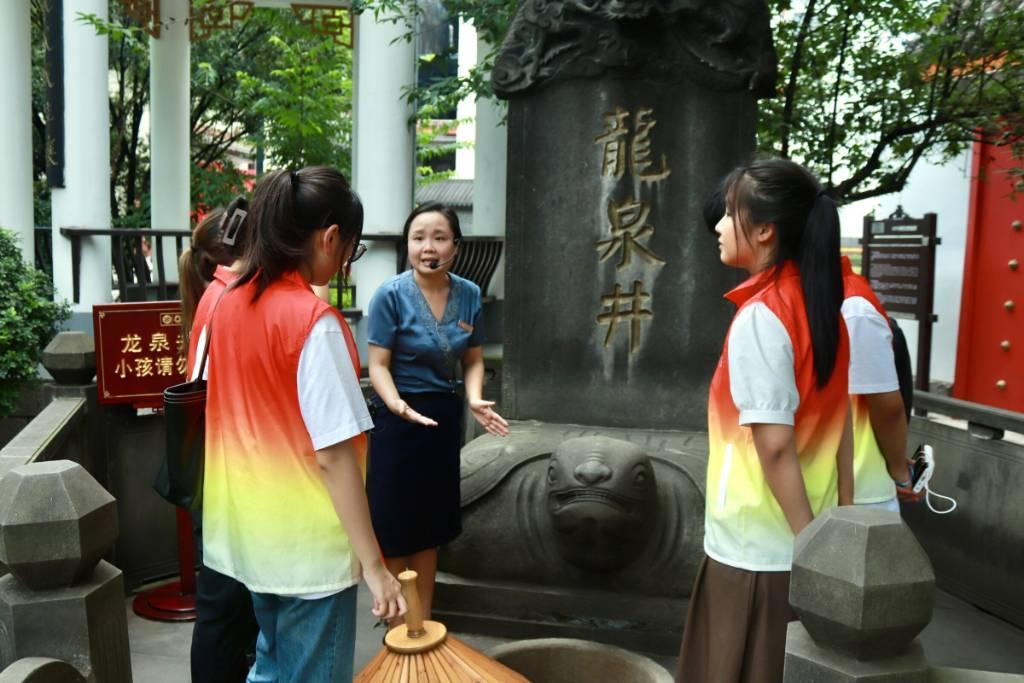 图为实践队在泸州老窖博物馆讲解员的带领下参观龙泉井井眼。朱春艳 摄