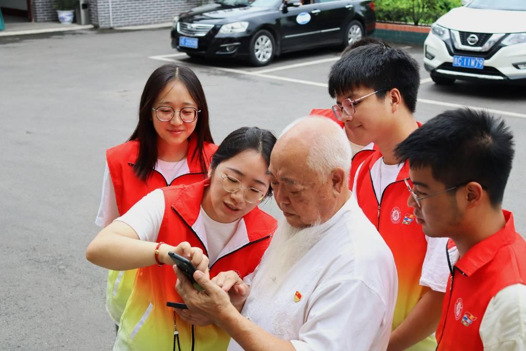 图为实践队带队老师刘春玲老师教胡敬华老人使用微信聊天功能。朱春艳 摄