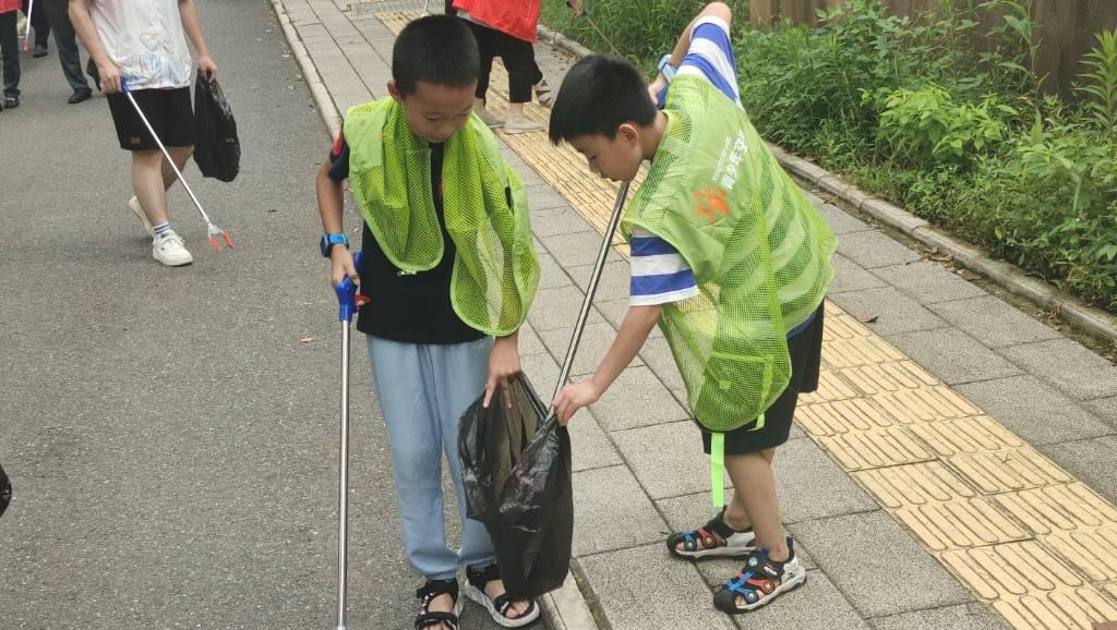 图为社区小朋友在社区周边的饭店桌子上粘贴杜绝浪费标语。（中国大学生网通讯员 吴语瞳 摄）