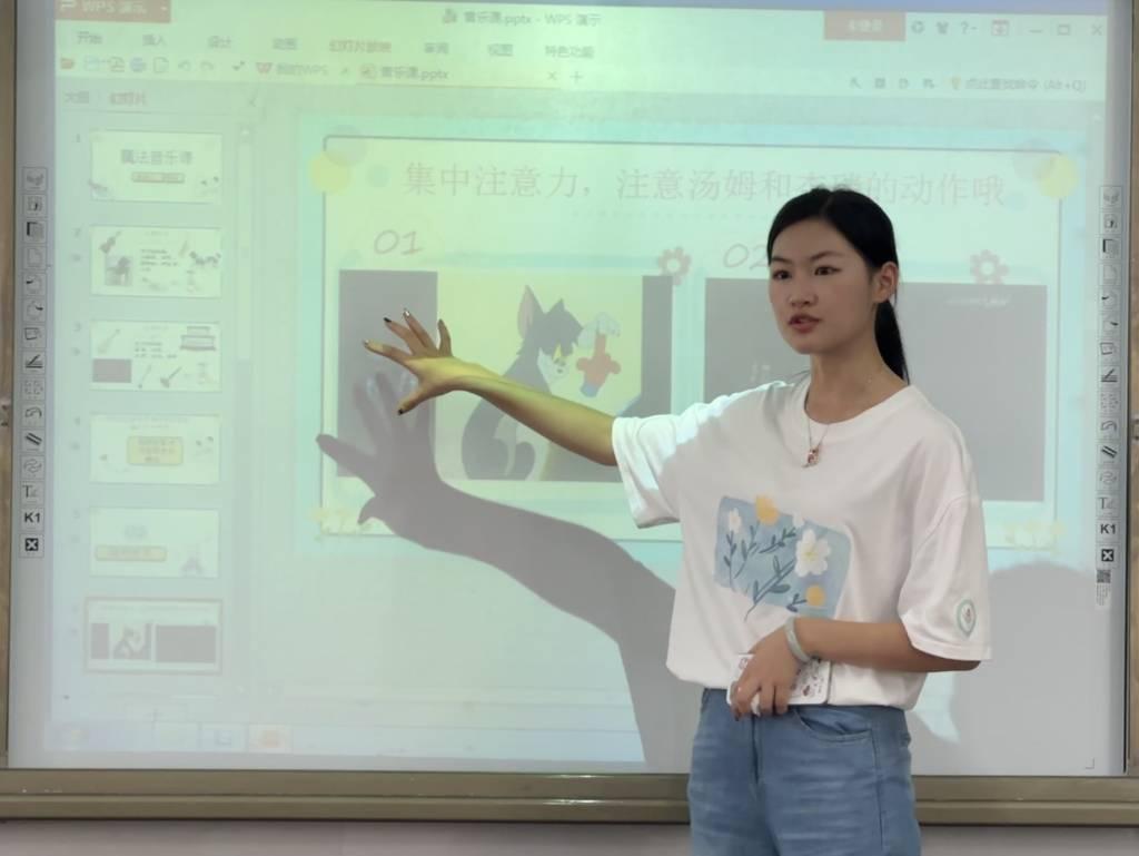 图为“蓓蕾”志愿服务队支教队员在音乐课上为同学们讲解动画片之中配乐的奥秘。大学生网报通讯员 何敏 供图