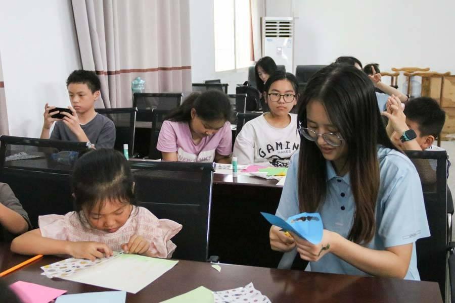 华中师范大学物理科学与技术学院党员国情学习与实践队队员协助孩子们进行拼贴