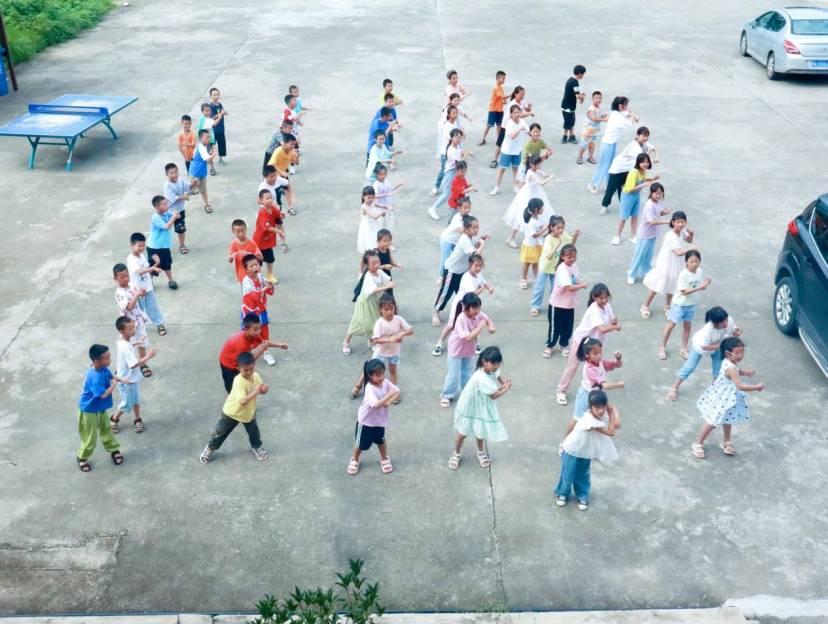 图为课间操时刻，小朋友们在空地上排列整齐，由实践队员带队教他们跳简单的舞蹈，进行课间操和课外放松。 通讯员 唐可欣 摄