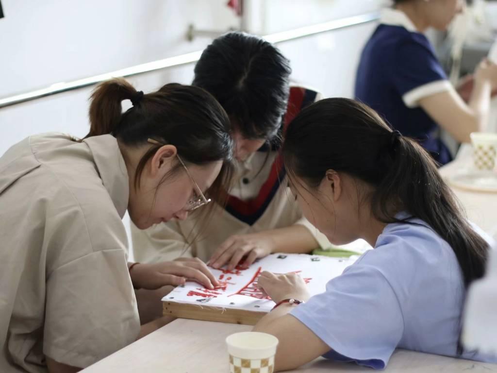 图为实践队员一起制作布贴式样的学校大门。通讯员 甘乐 供图