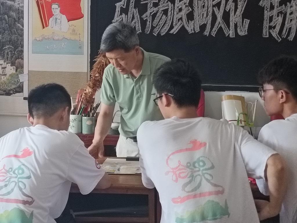 图为 胡友恒老师给同学们指点宣纸烙画作品的技巧。中国青年网通讯员 白智丘 摄