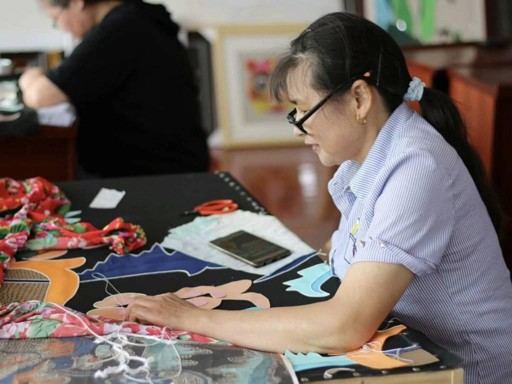 图为在制作室中，阳新布贴技艺传承人正在制作布贴，按设计图样对样布进行拼接。通讯员 甘乐 摄