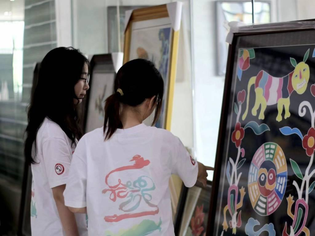 图为实践队成员们在展厅中认真欣赏布贴展品，不仅感叹制作布贴的智慧。通讯员 郭晓婷 摄