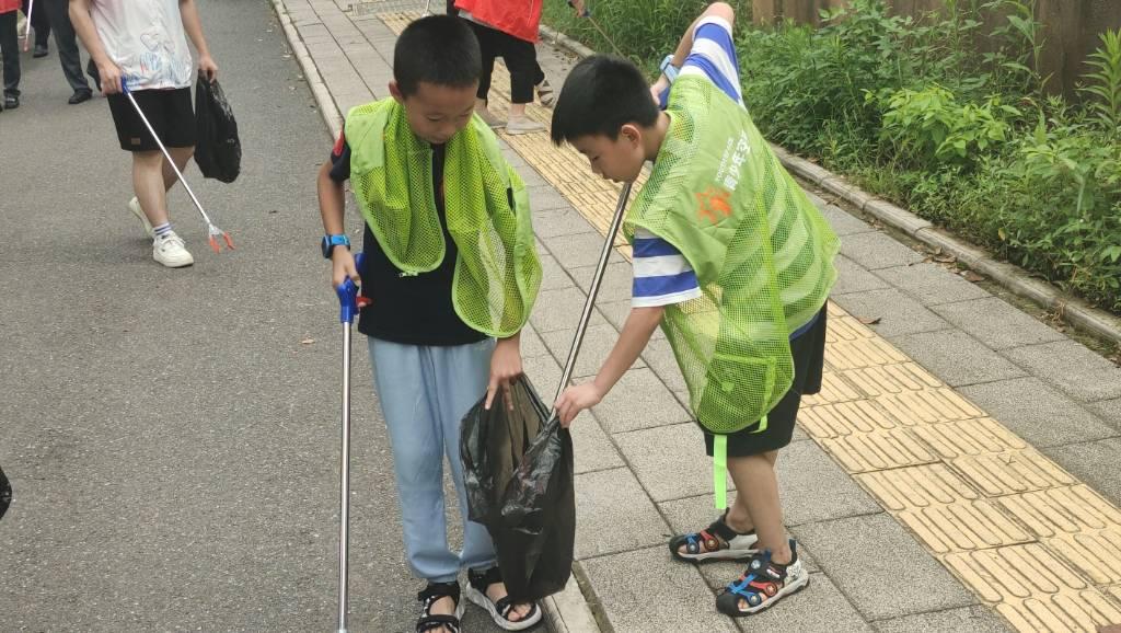 图为同学们同心协力、认真清扫天桥及街道周边环境卫生。大学生网报通讯员 肖淼 摄