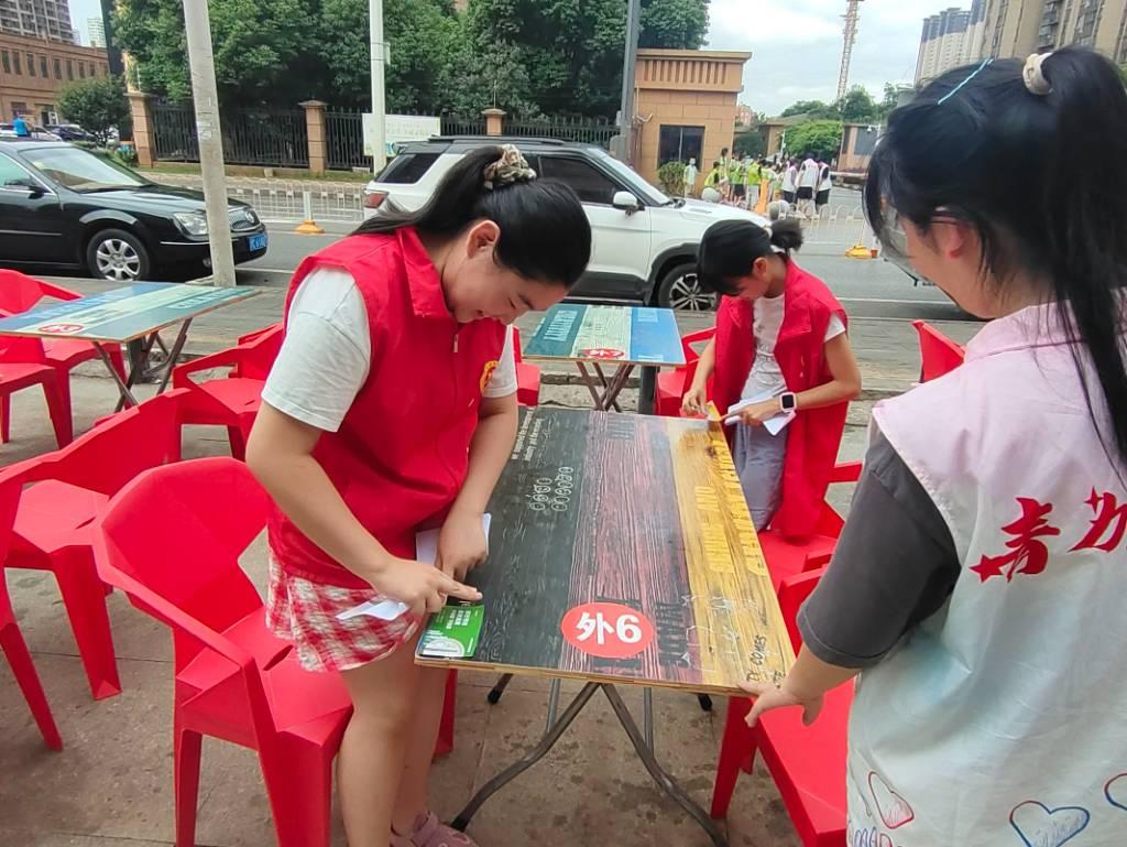 图为小朋友们帮助社区周围的商铺打扫卫生，减轻商铺工作人员的负担。中国大学生网报通讯员 赵梓茗 摄