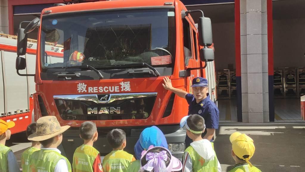 图为消防员为小朋友们介绍消防车，其中的各种特殊部件如何应用和面对的各种情况。