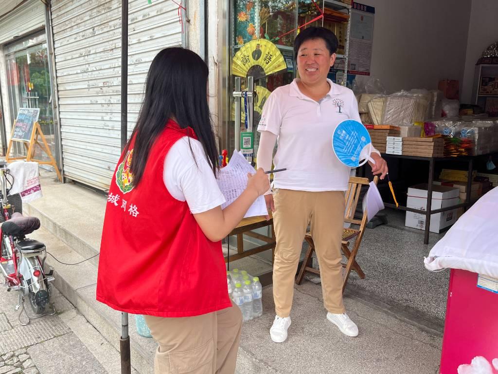 图为实践队员在宣传二十大精神，开展以青春心向党，社区志愿行为主题的社会实践活动。