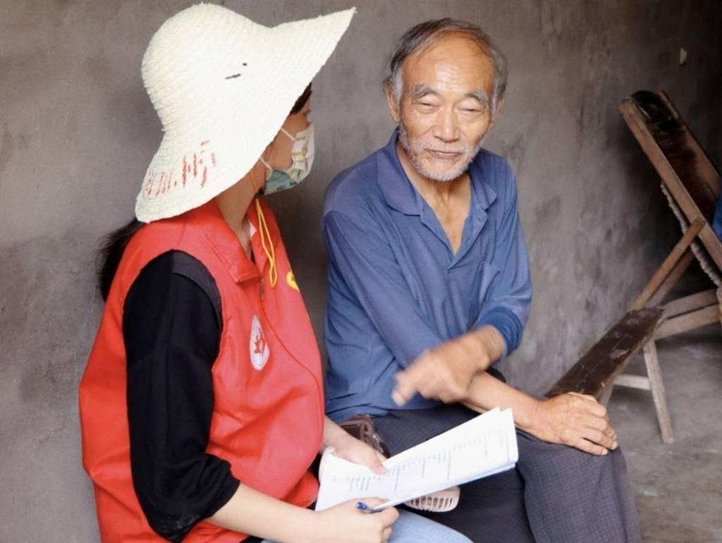 图为实践队员向居民普及二十大精神，开展以青春心向党，社区志愿行为主题的社会实践活动。