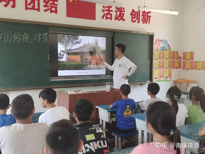 湖北汽车工业学院科技学院青锋·文源志愿服务队7月17日在襄阳市南漳县巡检镇完全小学开展了一系列特色课程，一节中国传统建筑课，让学生们对传统建筑有了更深的了解，对其背后所蕴含的深厚文化底蕴感到自豪，对传统建筑的传承和保护起到了重要作用。 图为老师正在为学生们展示中国的古典建筑。 中国青年网通讯员 黄智帆 摄